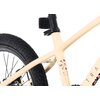 Fragment roweru dziecięcego w kolorze kremowo-fioletowym, z widocznym tylnym kołem i częścią ramy. Na ramie znajduje się napis "TATRA BIKES" oraz symbole kierunków N, W, S, E.