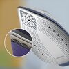 Zdjęcie przedstawia zbliżenie na stopę generatora pary z widocznymi otworami parowymi i napisem "PHILIPS Ceramic" na powierzchni. W lewym dolnym rogu znajduje się powiększenie fragmentu urządzenia, ukazujące szczegóły jego konstrukcji.