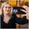 Na zdjęciu widoczne są cztery etui na telefon w różnych kolorach: czarnym, niebieskim, pomarańczowym i czerwonym, ułożone na drewnianej powierzchni. Na każdym etui znajduje się wytłoczony napis "FIXED".