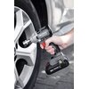 Na zdjęciu widoczny jest akumulatorowy klucz udarowy trzymany w dłoni, skierowany w stronę felgi samochodowej. Na urządzeniu znajduje się napis "GRAPHITE BRUSHLESS", a na akumulatorze widnieje oznaczenie "18V ENERGY+".