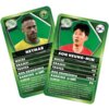 Na zdjęciu znajdują się dwie karty z gry karcianej "Top Trumps: World Football Star" z wizerunkami piłkarzy, ich imionami oraz statystykami: mecze, bramki, trofea, rok urodzenia i ranking. Na kartach widnieją również flagi krajów oraz ciekawostki związane