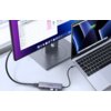 Na zdjęciu widoczny jest laptop podłączony do monitora za pomocą huba UGREEN CM511 5w1 USB Typu C, Pasywny, na którym znajduje się logo "UGREEN". Na ekranie monitora wyświetlone są ikony aplikacji oraz otwarte okno z folderem.