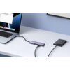 Na zdjęciu znajduje się laptop podłączony do huba UGREEN CM511 5w1 USB Typu C, który z kolei jest połączony z zewnętrznym dyskiem twardym. Na ekranie laptopa widoczne są ikony aplikacji oraz okno z listą plików.