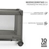 Szare łóżeczko turystyczne z siateczkowymi bokami i kółkami, z widocznymi napisami: "BEZPIECZEŃSTWO NA PIERWSZYM MIEJSCU!", "ZABEZPIECZONE NAROŻNIKI ŁÓŻECZKA", "BEZPIECZNE, TESTOWANE MATERIAŁY", "10 LAT GWARANCJI NAJWYŻSZY STANDARD JAKOŚCI" oraz logo "Kin