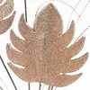 Dekoracyjny element w kształcie liścia pokryty złotym brokatem, z widocznymi cienkimi gałązkami w tle. Tło jest jasne, co podkreśla połyskliwą fakturę liścia.