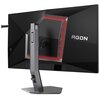 Czarny monitor z czerwonym podświetleniem z tyłu, zamontowany na srebrnej podstawie, z widocznym napisem "AGON". Monitor ma nowoczesny design z geometrycznymi kształtami na tylnej obudowie.