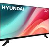 Telewizor z logo "HYUNDAI" w lewym górnym rogu i oznaczeniem "32''" w prawym górnym rogu, wyświetlający kolorowy gradient w odcieniach niebieskiego, różowego i czerwonego. Urządzenie stoi na dwóch czarnych nóżkach.