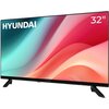 Na zdjęciu widoczny jest telewizor z logo "HYUNDAI" w lewym górnym rogu ekranu oraz oznaczeniem "32"" w prawym górnym rogu. Ekran wyświetla abstrakcyjny wzór w odcieniach różu, czerwieni i turkusu.