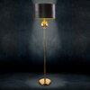 Czarna lampa podłogowa z okrągłym abażurem i złotą podstawą, ozdobiona szklaną kulą, stoi na ciemnym tle. Światło lampy tworzy delikatny blask wokół abażura.