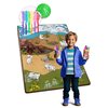Mata piankowa RICOKIDS Zwijana RK-344 120 x 90 cm przedstawia kolorową scenę z dinozaurami na tle krajobrazu z wulkanem i roślinnością, a obok niej znajduje się zestaw kolorowych pisaków. Na macie widoczne są kontury dinozaurów do pokolorowania.