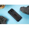 Czarny telefon z pomarańczowym napisem "ulefone" na tylnej obudowie, leży na niebieskim tle obok dwóch kawałków szarej skały i fragmentu modelu terenu. Telefon ma widoczną kamerę i śruby na obudowie.