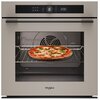Piekarnik elektryczny w kolorze szampańskim z widocznym wyświetlaczem cyfrowym i logo "Whirlpool" na froncie, wewnątrz którego znajduje się pizza na ruszcie. Na panelu sterowania widoczny jest czas "12:00" oraz różne ikony funkcji.