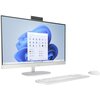 Komputer typu All-in-One z dużym ekranem, na którym wyświetlany jest interfejs systemu Windows 11 z widocznym menu Start. Przed monitorem znajdują się biała klawiatura i myszka, a na obudowie monitora widoczne jest logo producenta.