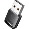 Na zdjęciu znajduje się czarny adapter USB z metalową wtyczką, na którym widnieje logo "UGREEN". Adapter ma małą, okrągłą diodę na obudowie.
