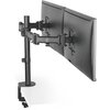 Czarny uchwyt do monitora ULTRADESK Skeleton Double zamontowany na białym blacie, trzymający dwa monitory obok siebie. Uchwyt posiada regulowane ramiona i solidną konstrukcję.