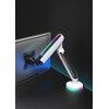 Biały uchwyt do monitora z podświetleniem LED w różnych kolorach, zamontowany na biurku, trzyma monitor. Uchwyt ma nowoczesny design z widocznymi elementami montażowymi i kolorowym oświetleniem.