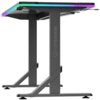 Czarne biurko gamingowe z podświetleniem RGB na krawędziach, z widocznym logo "ULTRADESK" na pionowej nodze. Konstrukcja biurka jest solidna, z metalowymi nogami i stabilizującymi wspornikami.