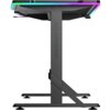 Czarne biurko gamingowe z podświetleniem RGB na krawędziach blatu, z widocznym logo "ULTRADESK" na pionowej nodze. Konstrukcja biurka jest solidna, z metalowymi elementami wspierającymi.
