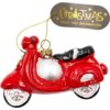 Czerwona bombka w kształcie skutera z czarnym siedzeniem i srebrnymi detalami, zawieszona na złotym sznurku. Obok znajduje się etykieta z napisem "CHRISTMAS JOLLY TREE DECORATION".