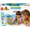 Pudełko zestawu LEGO 10449 DUPLO przedstawia kolorowy budynek z klocków oraz figurki, które bawią się na podłodze. Na opakowaniu widnieją napisy: "LEGO duplo", "10449", "IMAGINATION AND CREATIVITY", "LOGICAL THINKING", "EXPRESSING YOURSELF", "PLAY IDEAS",