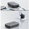 Na zdjęciu widoczny jest szary powerbank z napisem "AUKEY" oraz oznaczeniem "20000 mAh", podłączony do smartfona i ładowarki. Kabel z niebieskim podświetleniem wskazuje przepływ energii między urządzeniami.