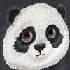 Na zdjęciu widoczne jest haftowane przedstawienie głowy pandy z dużymi oczami na czarnym tle. Panda ma białą sierść z czarnymi uszami, oczami i nosem, a jej wyraz twarzy jest uroczy i przyjazny.