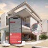 Na zdjęciu widoczny jest nowoczesny dom z dużymi przeszkleniami, a na pierwszym planie ekran smartfona z aplikacją pokazującą alert "Water Leak Sensor Triggered" oraz szczegóły dotyczące wykrycia wycieku wody. Obok znajduje się powiększone zdjęcie rury z wyciekiem wody, pod którą umieszczony jest czujnik zalania.
