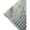 Zdjęcie przedstawia fragment dywanu zewnętrznego o wzorze w odcieniach turkusu, beżu i brązu, z geometrycznym motywem. Dywan jest częściowo zwinięty, ukazując teksturę i detale tkaniny.