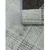 Zdjęcie przedstawia szary dywan zewnętrzny o teksturze złożonej z drobnych, geometrycznych wzorów. Jeden z rogów dywanu jest zrolowany, ukazując jego spód.