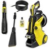 Na zdjęciu znajduje się żółto-czarna myjka ciśnieniowa z napisem "KARCHER K5 Smart Control" oraz akcesoria: wąż, lanca, butelka z płynem "UNIVERSAL" i inne elementy. Produkt ma widoczne logo "KARCHER".