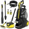 Na zdjęciu znajduje się myjka ciśnieniowa w kolorze czarno-żółtym z napisem "KARCHER K5 Power Control" oraz różne akcesoria, takie jak węże, szczotki i butelki z detergentami. Widoczne są również etykiety na butelkach z napisami "UNIVERSAL" i "STONE & FAC