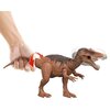 Na zdjęciu znajduje się figurka dinozaura z otwartą paszczą, trzymana za ogon przez rękę. Czerwona strzałka wskazuje na ruch ogona, a głowa dinozaura jest rozmyta, sugerując ruch.