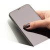 Na zdjęciu widoczny jest smartfon trzymany w dłoni, z nałożonym szkłem hartowanym, które pokrywa cały ekran. Szkło jest gładkie i błyszczące, a na ekranie nie ma widocznych napisów ani ikon.