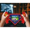 Czerwona zabawka konsola w kształcie logo Supermana z widocznym ekranem, na którym wyświetlana jest gra wyścigowa. Na konsoli znajdują się napisy: "Superman" oraz "Lexibook".