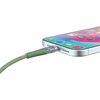Zielony kabel USB Typ-C - Lightning jest podłączony do smartfona, którego ekran wyświetla kolorowe ikony aplikacji. Kabel ma przezroczystą końcówkę, a obudowa telefonu jest srebrna z widocznymi otworami głośnika.
