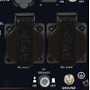Zdjęcie przedstawia panel z dwoma gniazdami elektrycznymi oznaczonymi jako "AC 250V" oraz przełącznikiem "AC BREAKER" z opcjami "ON" i "OFF". Obok znajduje się przycisk oznaczony jako "GROUND" oraz symbolem uziemienia.