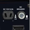 Na zdjęciu widoczny jest panel z gniazdem oznaczonym jako "DC 12V 8.3A" oraz przyciskiem z napisem "DC BREAKER". Obok przycisku znajdują się oznaczenia "ON" i "OFF".