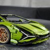 Zestaw LEGO Technic przedstawiający model samochodu Lamborghini Sian FKP 37 w kolorze zielonym, z widocznymi złotymi felgami i szczegółowymi elementami konstrukcyjnymi. Tło jest rozmyte, a powierzchnia, na której stoi model, ma marmurowy wzór.