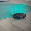 Na zdjęciu znajduje się granatowy robot sprzątający na podłodze, obok którego widoczna jest siatka symbolizująca obszar sprzątania. Na robocie widnieje logo "PHILIPS".