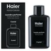 Czarne opakowanie i butelka z napisem "Haier Premium Collection" oraz "Laundry perfume Profumo per bucato Parfum pour lessive Crystal". Na opakowaniu znajduje się zarys butelki, a na butelce widnieje ten sam tekst co na opakowaniu.