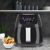 Czarna frytkownica beztłuszczowa z wyświetlaczem cyfrowym i przyciskami dotykowymi, na którym widnieje napis "200°C 10 min", stoi na blacie kuchennym. Obok znajduje się miska z frytkami, a w tle widać półkę z naczyniami i roślinę w doniczce.