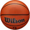 Na zdjęciu widoczna jest pomarańczowa piłka koszykowa z czarnymi liniami, z dużym napisem "Wilson" na środku. Na dole piłki znajduje się małe logo oraz podpis.