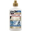 Biała butelka z brązowym korkiem zawiera produkt "FINISH LINE Ceramic Wax Chain Lube" o pojemności 120 ml. Na etykiecie widnieje napis "MAXIMUM CLEANLINESS" oraz zdjęcie rowerzystów.