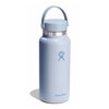 Niebieska butelka termiczna z uchwytem, posiada logo w kształcie stylizowanej dłoni oraz napis "Hydro Flask" na dole. Butelka ma szeroki otwór i zakrętkę z elastycznym uchwytem.