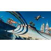 Na zdjęciu widać skatepark z rampą, nad którą unosi się postać w dynamicznej pozie. W tle znajdują się kolorowe zjeżdżalnie wodne, palmy oraz wieżyczki przypominające zamkowe baszty, a niebo jest bezchmurne i jasnoniebieskie.