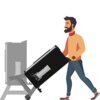 Ilustracja przedstawia osobę przesuwającą czarną, mobilną podstawę do wędzarni z widocznym metalowym elementem. W tle znajduje się zarys wędzarni w szarym kolorze.