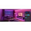 Na zdjęciu znajduje się opakowanie produktu "Govee RGB LED Strip Light" z widoczną grafiką przedstawiającą świecącą taśmę LED w kolorach niebieskim i fioletowym. Obok opakowania leży rozwinięta taśma LED oraz smartfon z aplikacją Govee, a także widoczny j