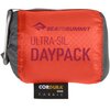 Czerwony plecak miejski z napisem "SEATOSUMMIT ULTRA-SIL DAYPACK" jest widoczny na zdjęciu, złożony w kompaktową formę. Na dole znajduje się czarna metka z napisem "CORDURA BRAND FABRIC".