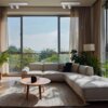Na zdjęciu znajduje się jasny salon z dużym oknem, przez które widać zieleń na zewnątrz. W pomieszczeniu znajduje się narożna sofa, okrągły stolik z kubkiem oraz rośliny doniczkowe, a na suficie zamontowane są białe kinkiety.