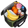 Zielona torba termiczna NILS CAMP NC2904 o pojemności 20 litrów zawiera różne produkty spożywcze, w tym banany, pomarańcze, napoje w puszkach, butelkę wody, opakowanie z napisem "Głodniak Paluszki" oraz plastikowy pojemnik. Na torbie widoczne jest logo "N
